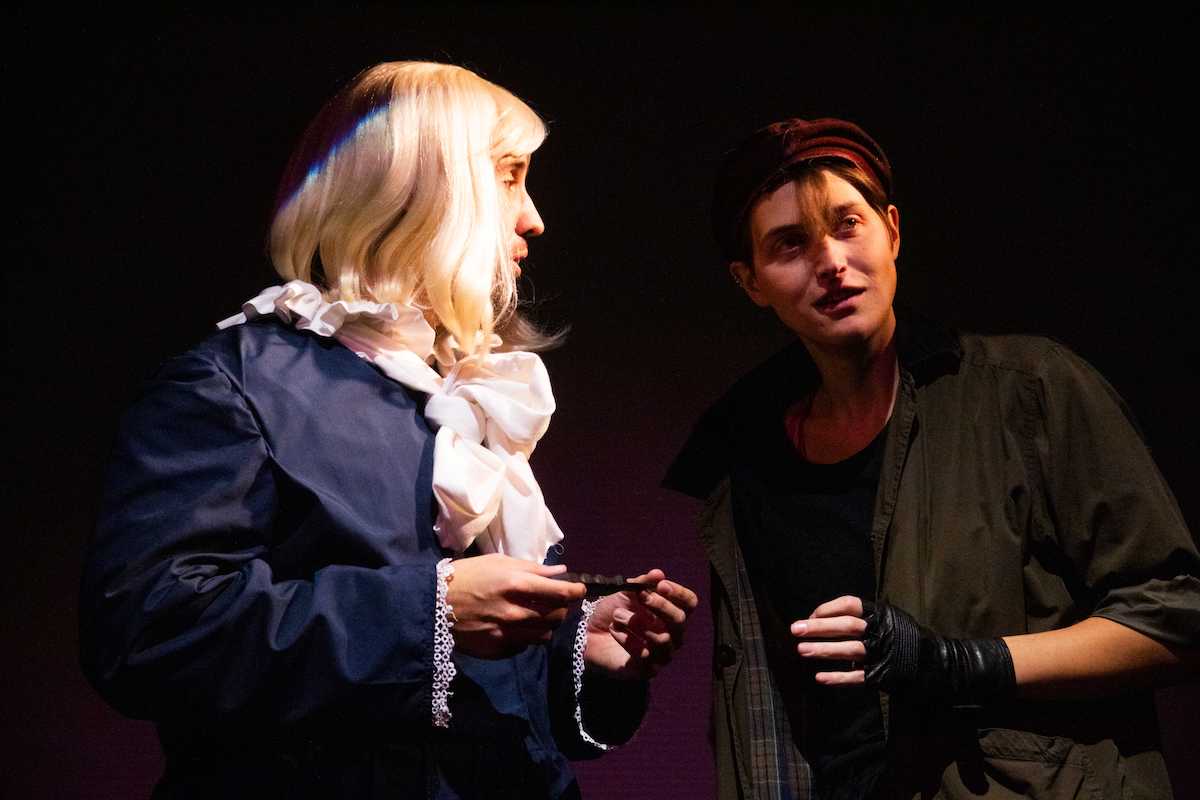 A man and woman exchange words on stage.